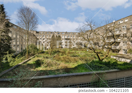 an urban area with buildings and trees in the fore - image taken from below, looking up at one of the rooftops 104221105