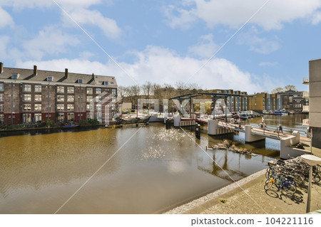 some buildings and boats on the water in front of a body of water with blue skies overhead above, there is a cloudy sky some buildings and boats on the water in front of a body of water with blue skies overhead above, there is a cloudy sky 104221116