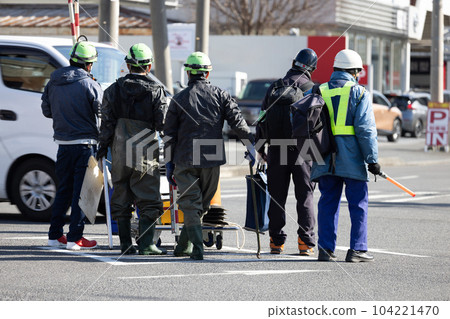 Workers withdrawing after completing road repair work at the intersection Workers withdrawing after completing road repair work at the intersection 104221470