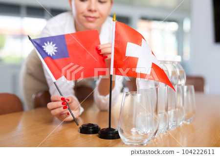 Little flag of Switzerland on table and flag of Taiwan put next to it by young woman 104222611