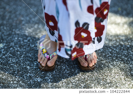 Feet wearing clogs of a young woman wearing a yukata Feet wearing clogs of a young woman wearing a yukata 104222844