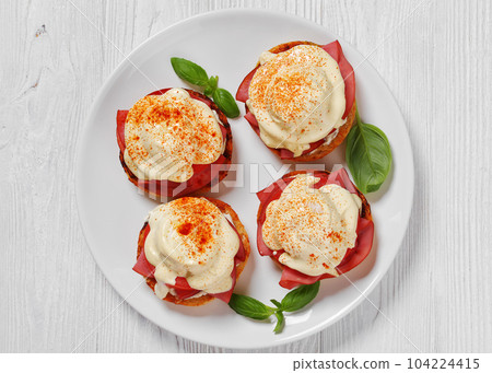 Eggs Benedict on white plate, top view Eggs Benedict on white plate, top view 104224415
