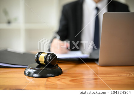 Close-up image of a judge gavel or judge hammer is on a wooden desk in a lawyer office. 104224564