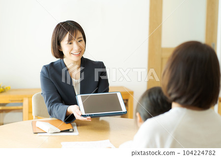 一位商務人士與父母和孩子交談的照片 104224782