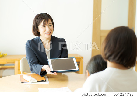 一位商務人士與父母和孩子交談的照片 104224783