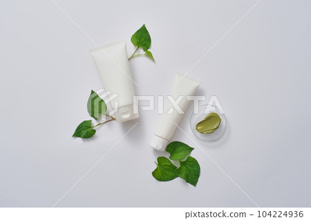 Two tubes displayed with green smears of cream texture on small podium. Empty label for cosmetic product mockup extracted from Fish mint (Houttuynia cordata) Two tubes displayed with green smears of cream texture on small podium. Empty label for cosmetic product mockup extracted from Fish mint (Houttuynia cordata) 104224936