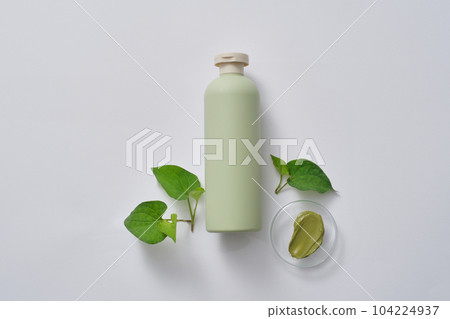 Pastel bottle without label decorated with few fish mint leaves and green texture. Fish mint (Houttuynia cordata) can increase the production of red blood cells Pastel bottle without label decorated with few fish mint leaves and green texture. Fish mint (Houttuynia cordata) can increase the production of red blood cells 104224937