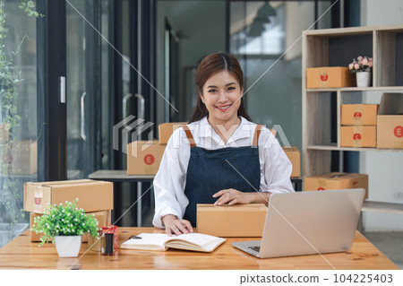 Happy young asian woman startup small business computer laptop and sitting on chair, Online marketing packing box delivery concept Happy young asian woman startup small business computer laptop and sitting on chair, Online marketing packing box delivery concept 104225403