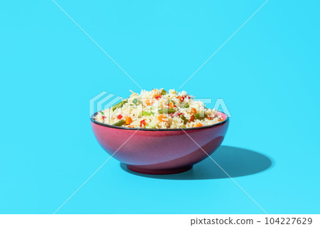 Fried rice with vegetables, an asian dish, on a blue background Fried rice with vegetables, an asian dish, on a blue background 104227629