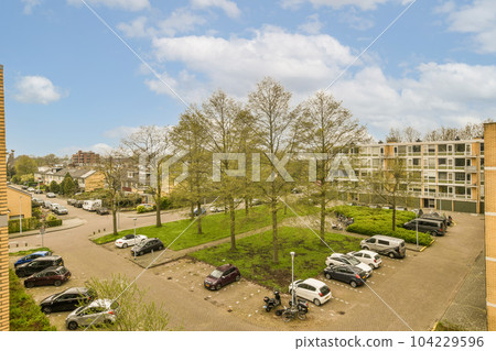 a parking area with cars parked in the lot and trees growing on the other side of the street, as seen from above a parking area with cars parked in the lot and trees growing on the other side of the street, as seen from above 104229596