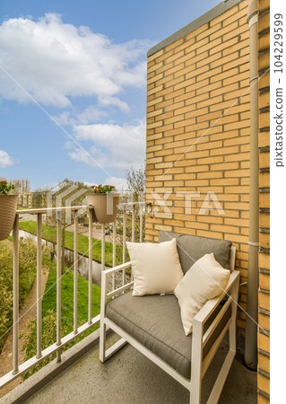 an outside area with a couch and some plants on the other side of the building, in front of a blue sky an outside area with a couch and some plants on the other side of the building, in front of a blue sky 104229599