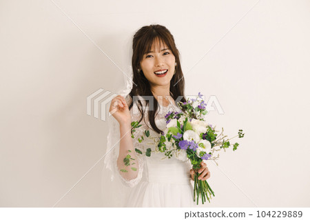 A woman in a wedding dress, a bride with a bouquet A woman in a wedding dress, a bride with a bouquet 104229889