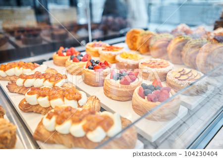 A variety of fresh pastries in the bakery window. almond croissant is fresh and hot in a cafe next to other types of pastries. fresh pastries with berries. The interior of an Italian restaurant. 104230404