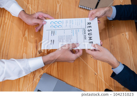 Candidate handing resume or CV over table to interviewer. Entity Candidate handing resume or CV over table to interviewer. Entity 104231023