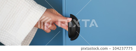 Female hand opening door of blue wardrobe at home closeup Female hand opening door of blue wardrobe at home closeup 104237775