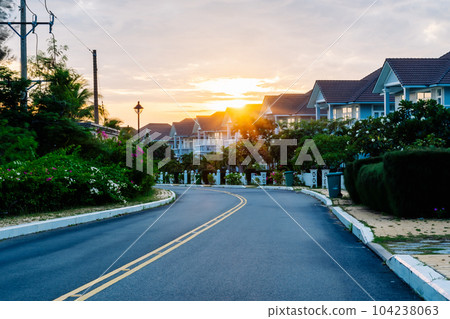 Modern cottages row road sidewalk two story buildings residential villas village New Estate Reflection dawn Sun in windows  104238063