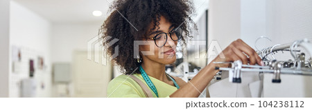 Happy African-American fashion designer takes cardboard basic pa Happy African-American fashion designer takes cardboard basic pa 104238112