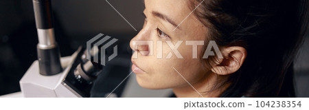 Thoughtful Asian woman in uniform with modern microscope at workplace in hospital laboratory Thoughtful Asian woman in uniform with modern microscope at workplace in hospital laboratory 104238354