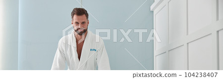 Cheerful man in soft bathrobe leans onto hydro massage tub with hot water in spa salon Cheerful man in soft bathrobe leans onto hydro massage tub with hot water in spa salon 104238407