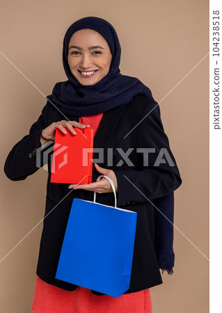 Muslim woman in hijab standing with shopping bags 104238518