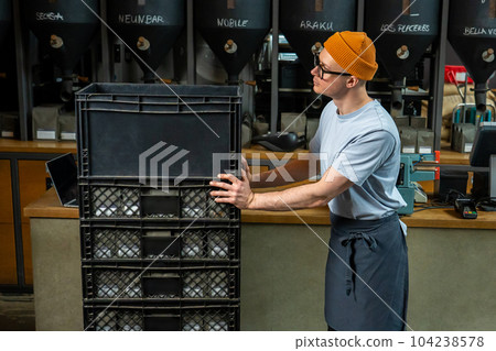 Barista bartender unloads new batch of coffee for coffee brewing in cafe. 104238578