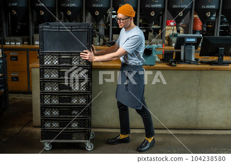 Barista accepts new batch of coffee unpacking boxes, preparing for working process in coffee shop. Barista accepts new batch of coffee unpacking boxes, preparing for working process in coffee shop. 104238580