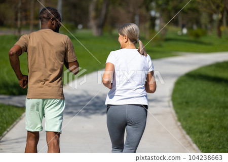 Mature couple jogging in the park together Mature couple jogging in the park together 104238663