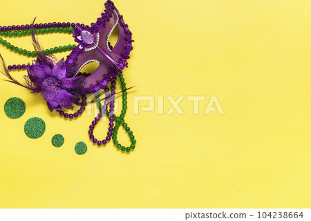 Mardi gras concept. Congratulation card with violet mask on yellow background Top view 2023 Mardi Gras Parade Schedule Mockup Copy space. 104238664