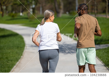 Mature couple jogging in the park together Mature couple jogging in the park together 104238666