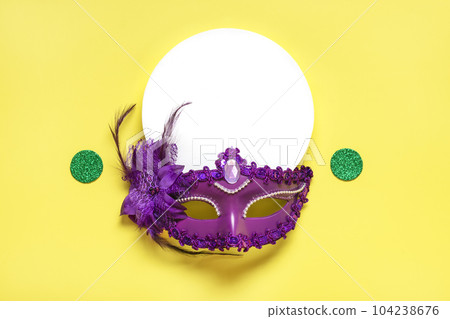 Mardi gras concept. Congratulation card with violet mask on yellow background Top view 2023 Mardi Gras Parade Schedule Mockup Copy space. 104238676
