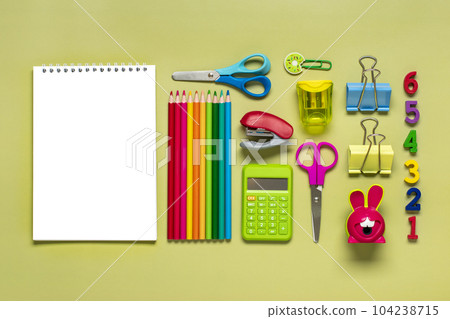 Frame from school and office supplies Paper clips, pens, calculator, sharpener, notepad, stapler isolated on green background Flat lay Top view Back to school, education concept Mock up Copy space. 104238715