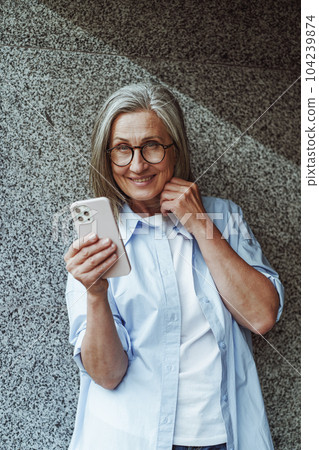 Concept of communication in old age, mature senior woman using mobile phone for texting and internet messengers. Woman's active engagement with technology and desire to stay connected in digital age Concept of communication in old age, mature senior woman using mobile phone for texting and internet messengers. Woman's active engagement with technology and desire to stay connected in digital age 104239874