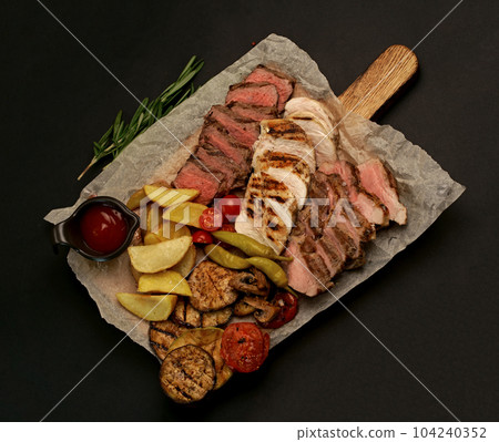 grilled meat. several types of grilled meat cut on a wooden board 104240352