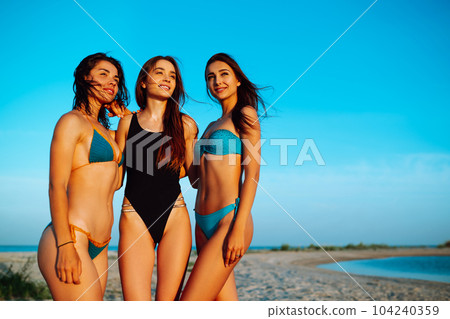 Portrait of three beautiful girls on the beach. Young women enjoying on beach holiday. Summer holidays. Portrait of three beautiful girls on the beach. Young women enjoying on beach holiday. Summer holidays. 104240359