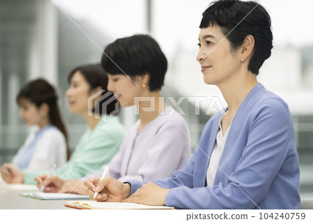 Middle-aged women attending a seminar Middle-aged women attending a seminar 104240759