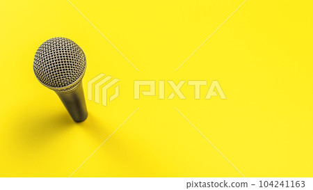 Black microphone with silver grind on yellow board, space for text right 104241163