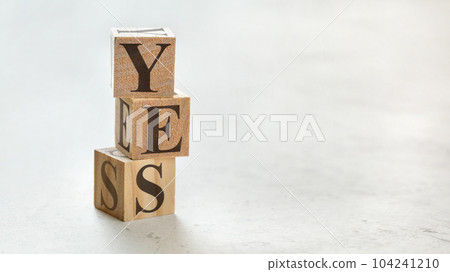 Pile with three wooden cubes - word YES on them, space for more text / images at right side. 104241210