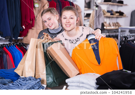 Woman and daughter after shopping in clothing store 104241958