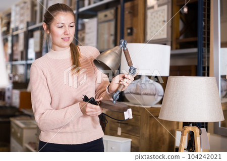 cheerful woman buyer choosing lamp cheerful woman buyer choosing lamp 104242021