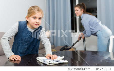 Girl helping mother with cleaning Girl helping mother with cleaning 104242205