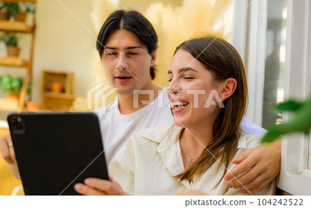 Couple of romantic young people using laptop at home 104242522