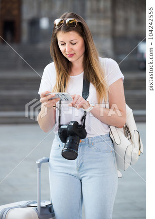 Young traveling girl searching for the direction using her phone in the town Young traveling girl searching for the direction using her phone in the town 104242556