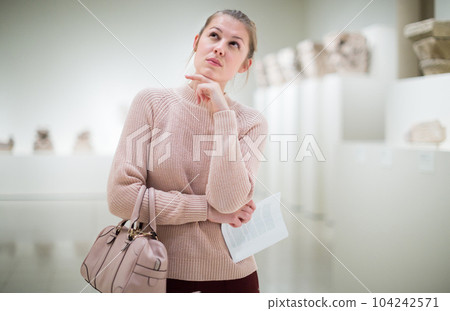Woman with guide-book in art museum of sculptures 104242571