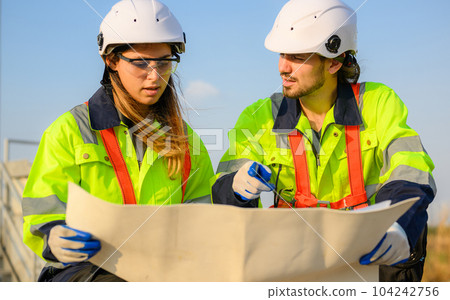 Engineer technician with safety uniform working at wind turbine field 104242756