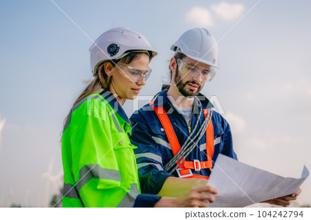 Professional engineer technician working outdoor at wind turbine field 104242794