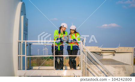 Professional engineer technician working outdoor at wind turbine field 104242800