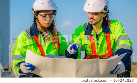 Professional engineer technician working outdoor at wind turbine field 104242828