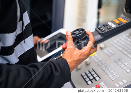 Engineer mechanician operating and controlling CNC machine Engineer mechanician operating and controlling CNC machine 104243396
