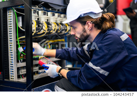 Technician engineer holding robot controller checking automatic robotic machine 104243457
