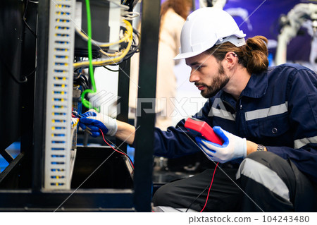 Technician engineer holding robot controller checking automatic robotic machine Technician engineer holding robot controller checking automatic robotic machine 104243480